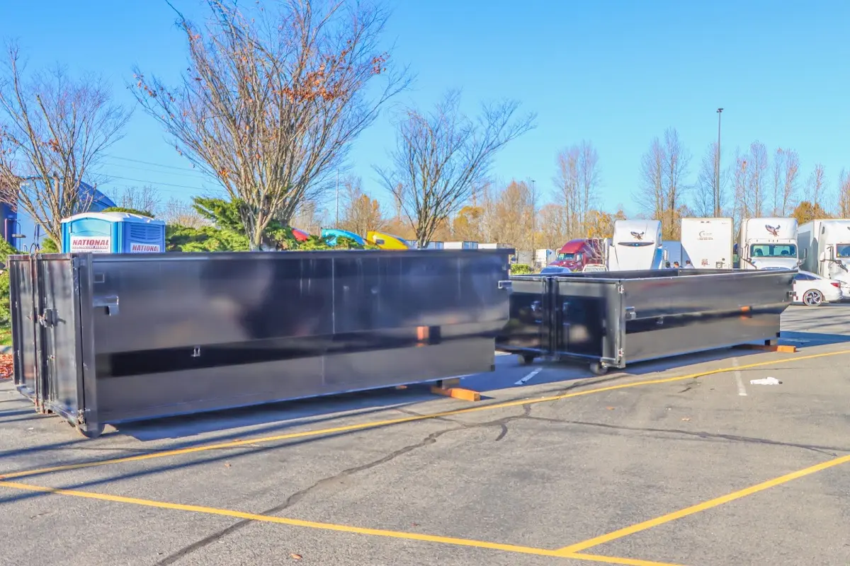 Professional dumpster rental service with roll-off container on residential driveway in Vinita